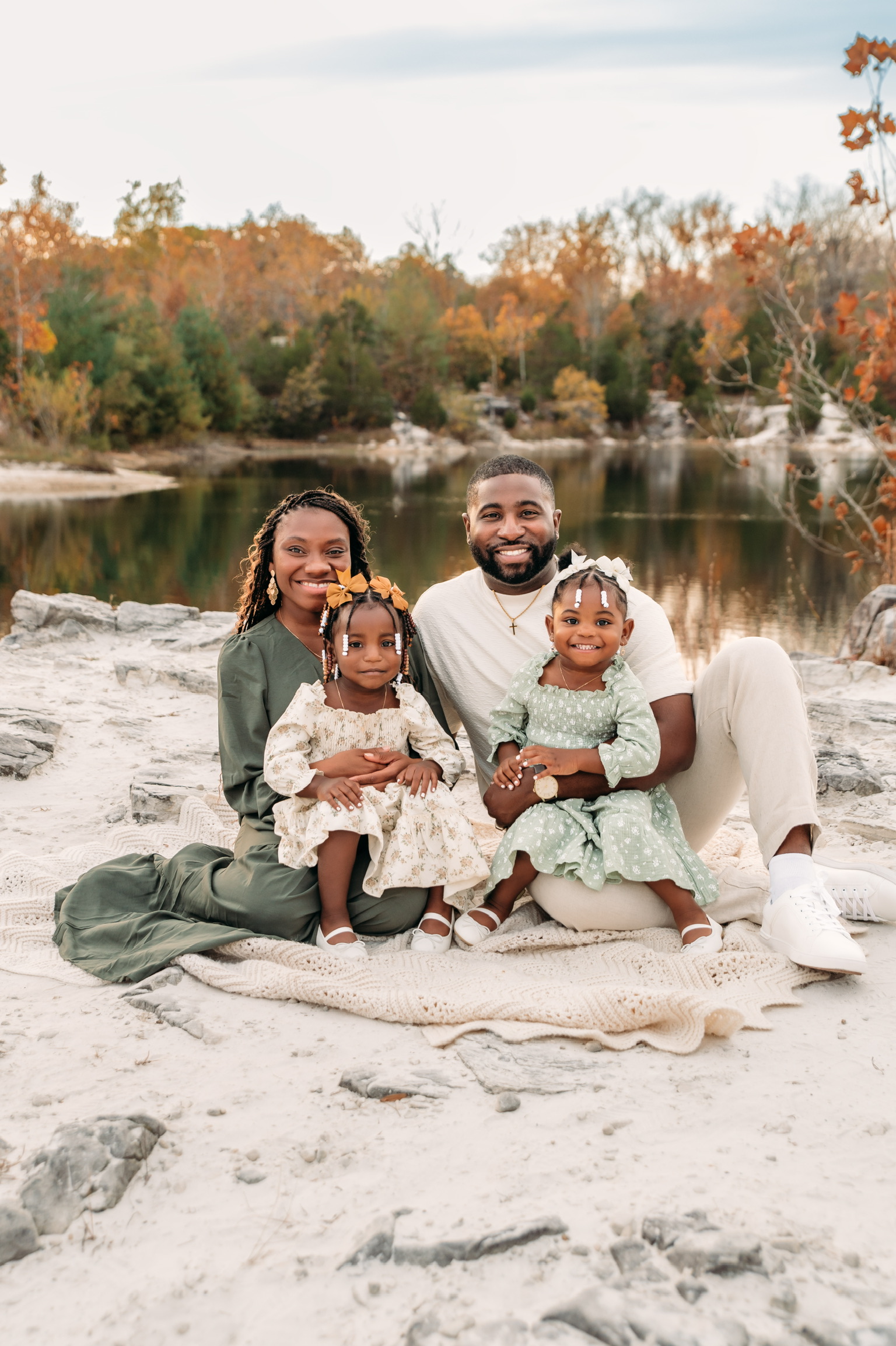 The family sitting together beside the lake in autumn